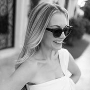 Woman wearing sunglasses and a strapless dress outdoors